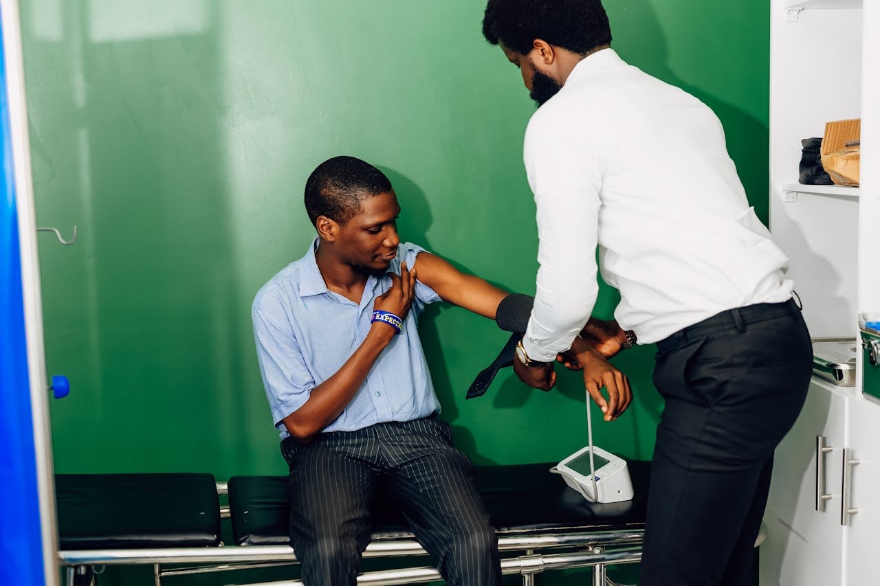 Healthcare professional measuring a patient's blood pressure during a clinical consultation in a primary health care setting.